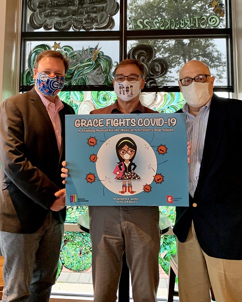 Author Ken Korber holding Grace Fights COVID-19 book cover with Eckhartz Press publishers Rick Kaempfer and David Stern