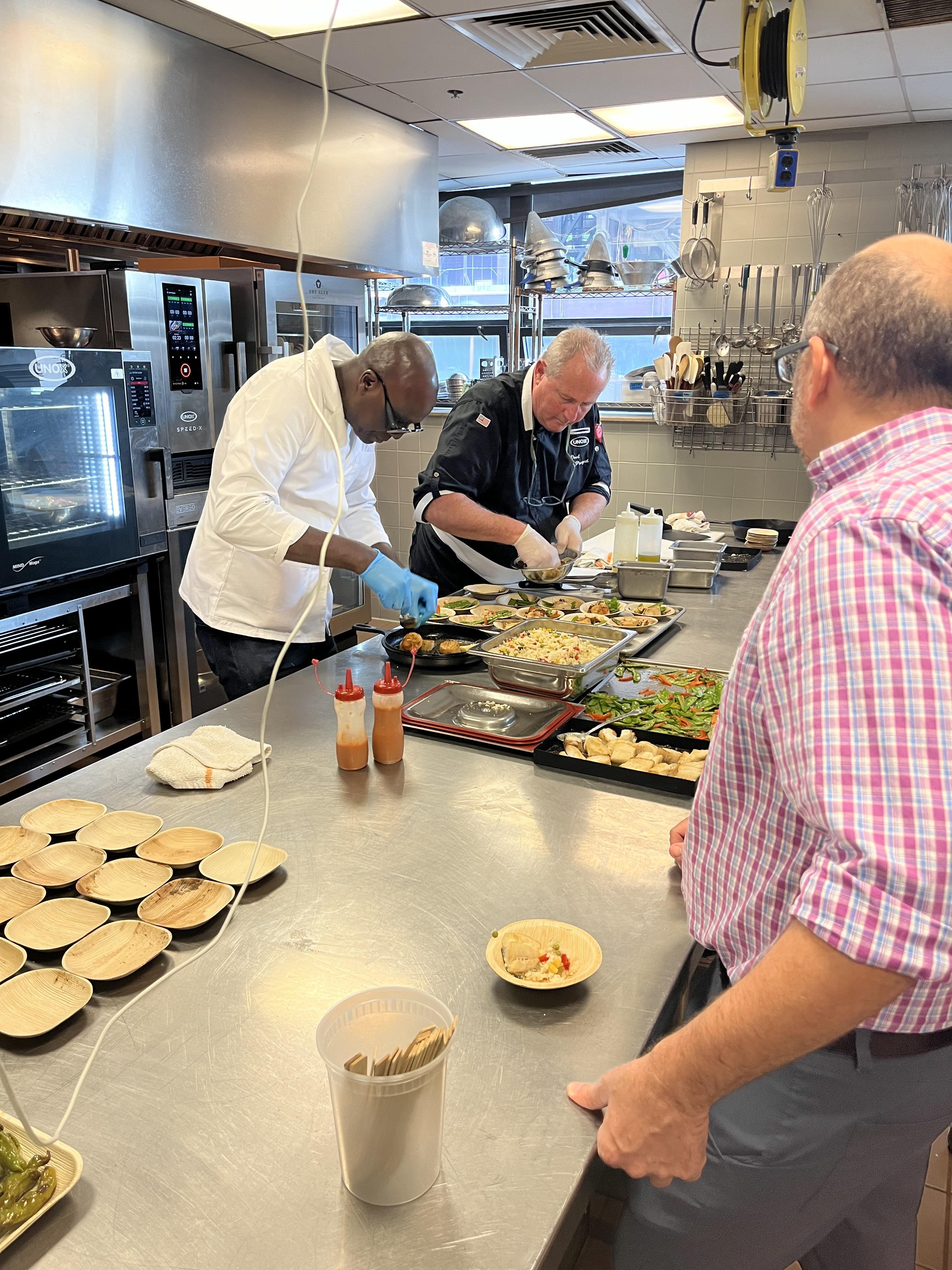 Two chefs plating food for tastings