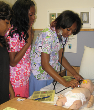 High school students dress in scrubs for hands-on simulation experience.