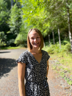Kate Worwag standing in front of nature scenery.