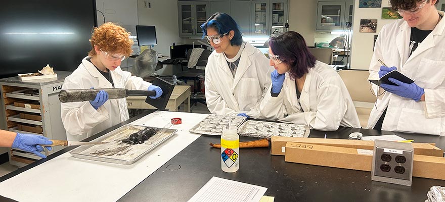Drexel BEES students examine a core sample of sediment in the lab.
