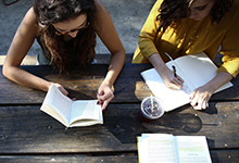 Young women studying at an outdoors table