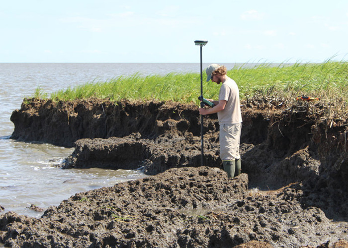 Wetlands Project Coordinator Kirk Raper uses an RTK GPS to measure significant coastline erosion at Bombay Hook National Wildlife Refuge. Photo by Rockwell Geyer