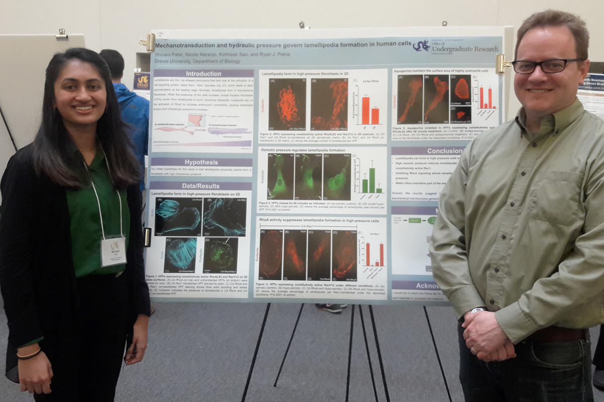 Shivani Patel and Ryan Petrie stand in front of a research poster