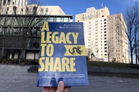 A copy of the book A Legacy to Share held up on Drexel's campus