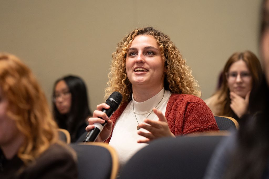 A student participates in a Q&A after a lecture