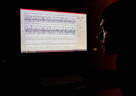 Researcher looking at Brainwaves on Computer Monitor