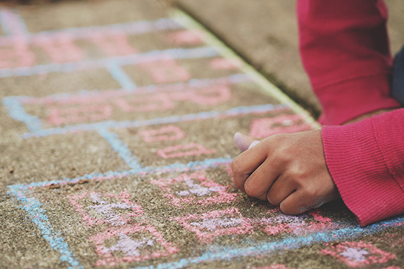 Child drawing with chalk on a sidewalk