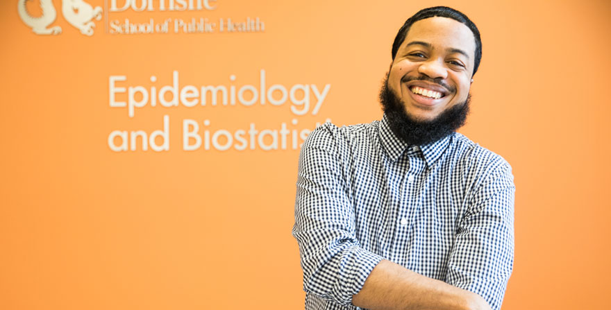 Young man in from of a department sign for Epidemiology and Biostatistics