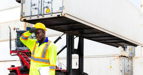 worker outside in heat wiping sweat from his brow