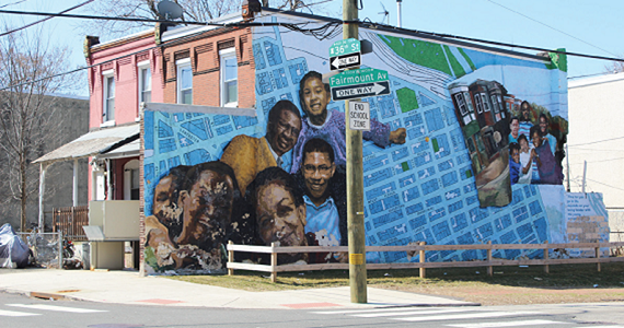 Street level view of West Philadelphia mural depicting community members and a map of city