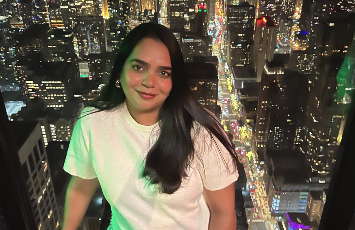 Student smiles on rooftop deck in city