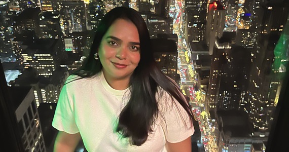 Student smiles on rooftop deck in city