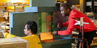 Two students working on computer equipment