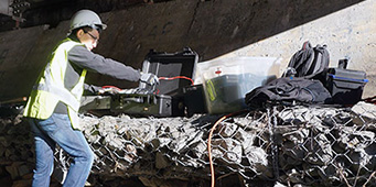 Man in hardhat monitoring bridge structure