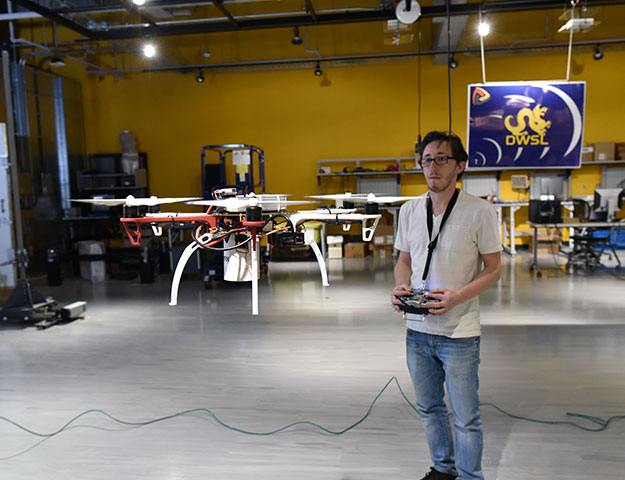 Student working with drone in lab.