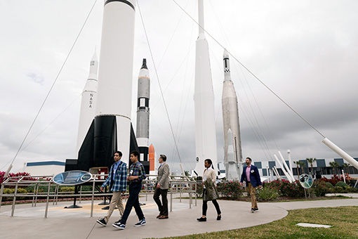 Guests walk by rockets at the Kennedy Space Center.