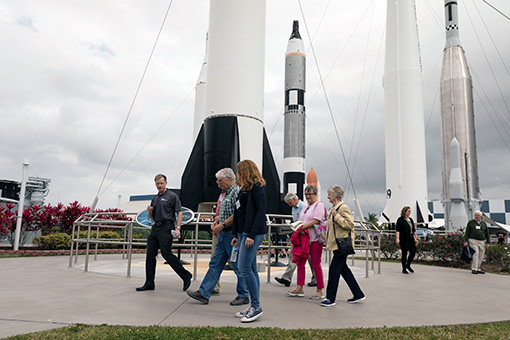 Guests walk by rockets at the Kennedy Space Center.