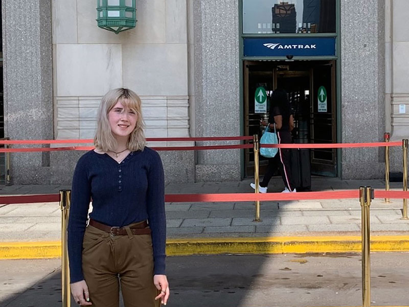 Young woman standing in front of Amtrak station