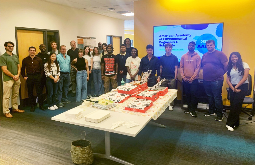A group of students standing around a table. 
