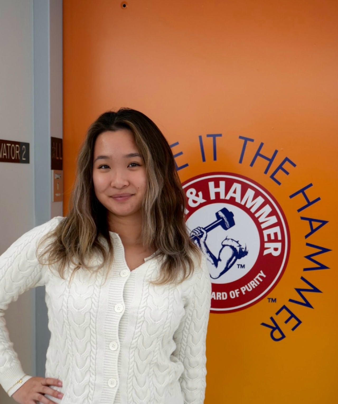 Vivan Le stands in front of an Arm and Hammer logo