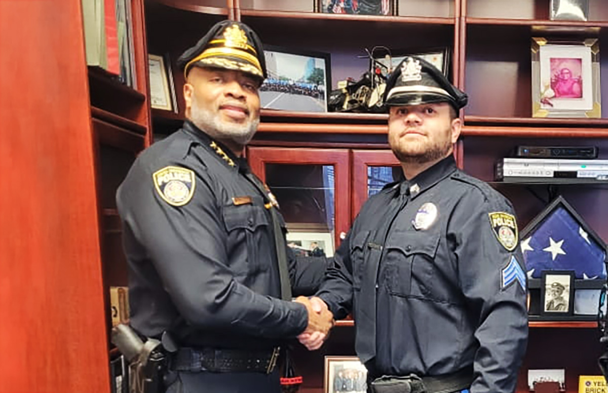 Adkins (right) shakes hands with hands with Vice President of Public Safety Mel Singleton Jr