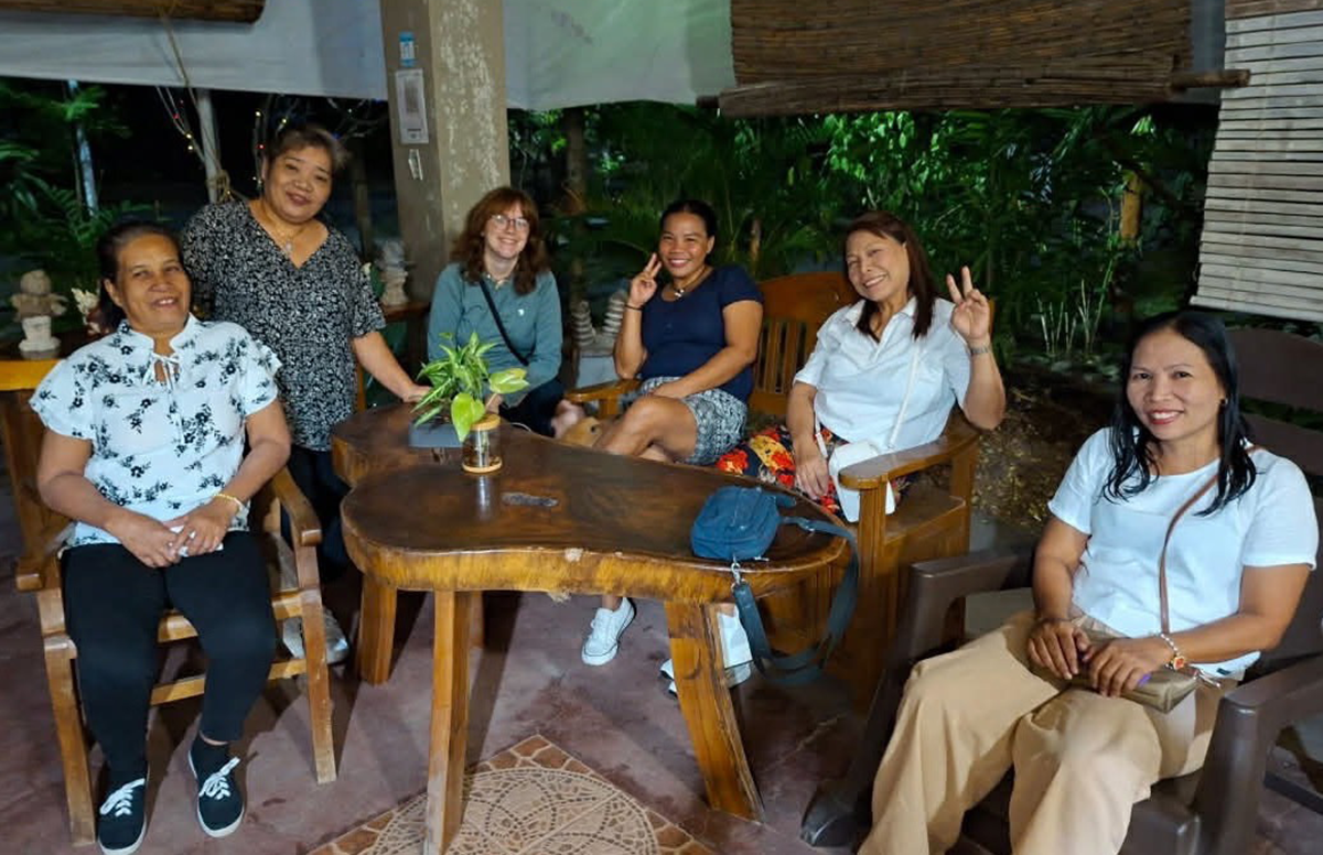 Alyssa Kemp sits with local women