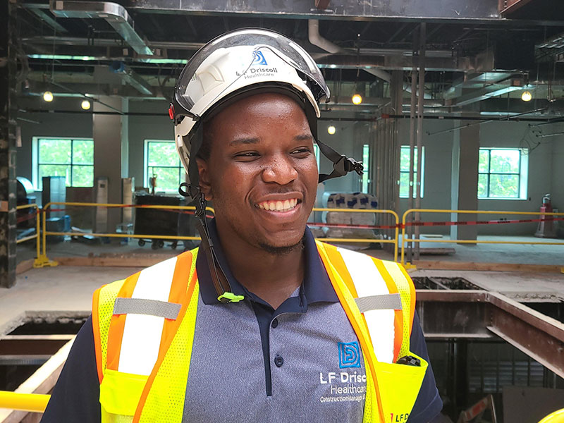Young Black man in hard hat and safety vest at construction site