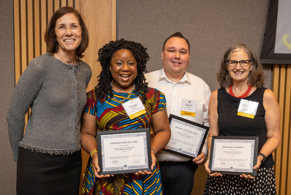 Four Faculty Award Winners holding framed awards