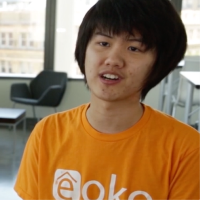 young man with short black hair and orange shirt