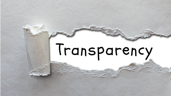 Image of a paper ripped with the word transparency behind it.