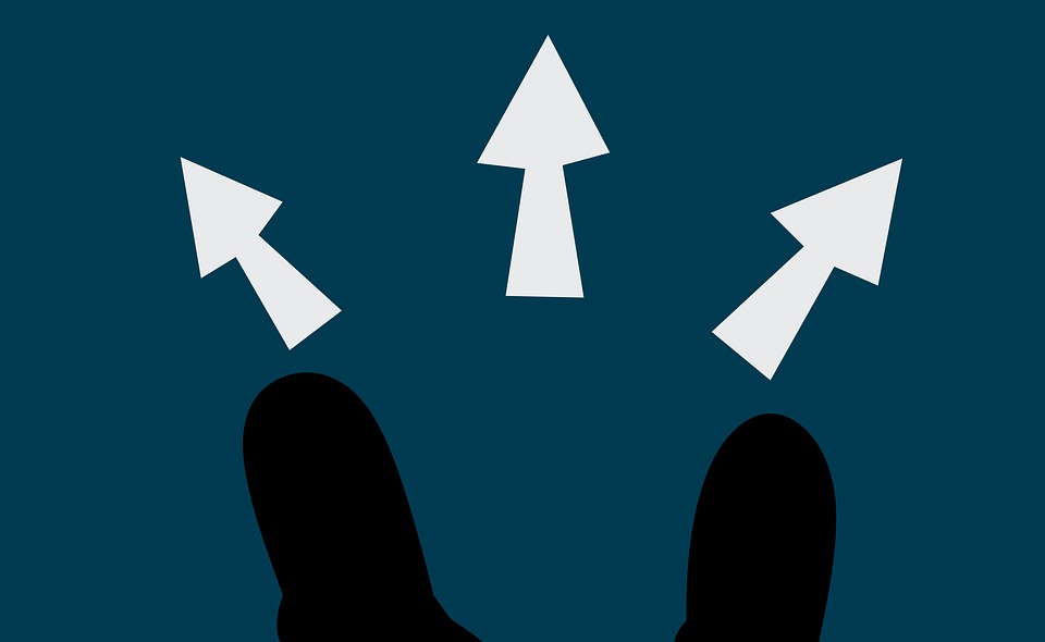 Image of two illustrated feet with three arrows in front, indicating a decision is needed to determine which direction to take.
