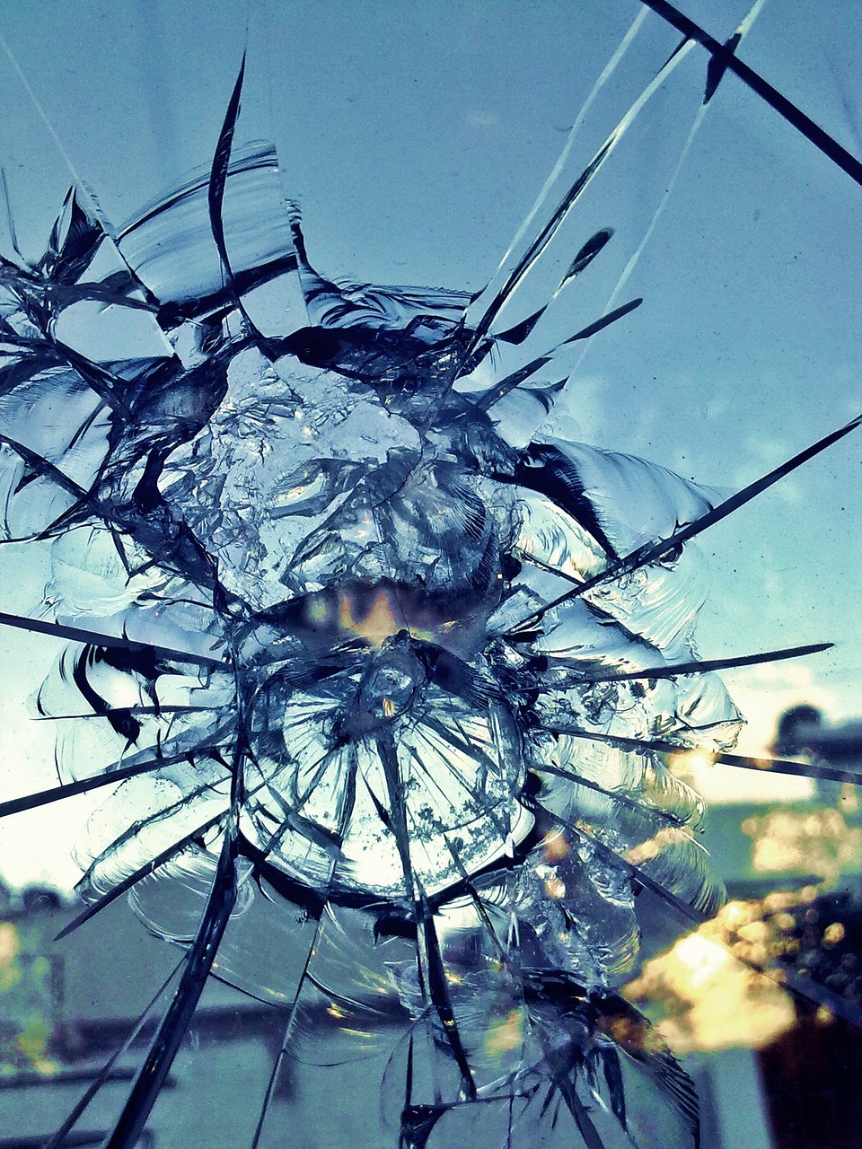 Image of a broken window - or glass ceiling with many cracks feathering outward.