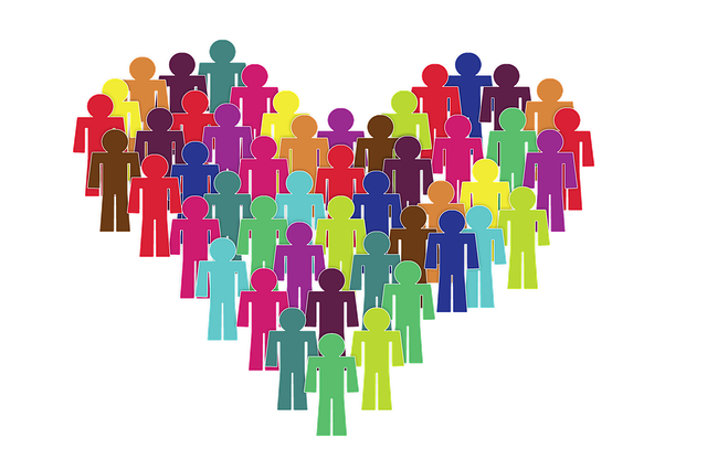 Image of a rainbow of people standing in the shape of a heart