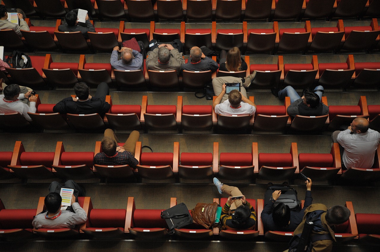 Image of a auditorium with people sitting in the seats