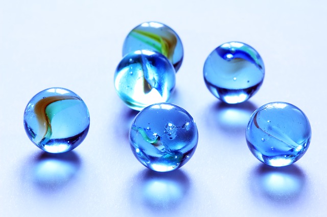 Image of 6 shiny blue marbles on a blank white surface