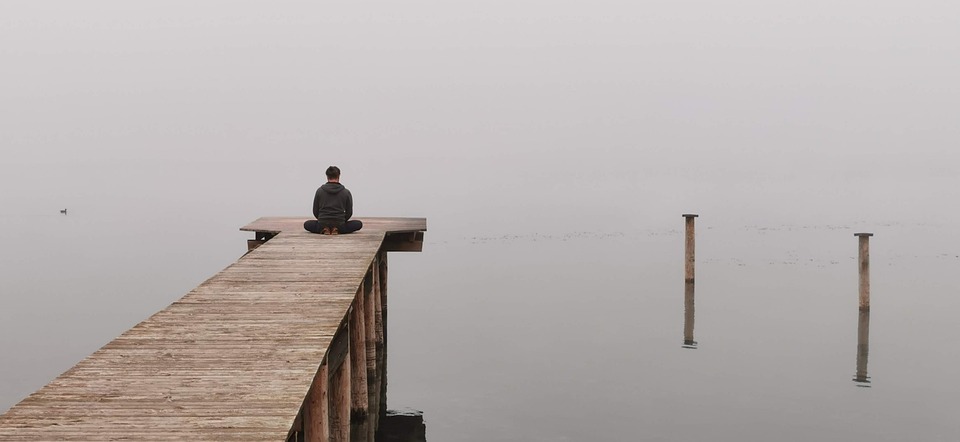 Image of a lake or body of water with a dock heading into it, to simulate calmness