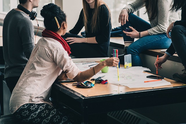 Image of millennial workers sitting around a desk collaborating.