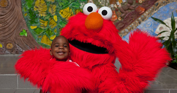 Little boy posing with Elmo