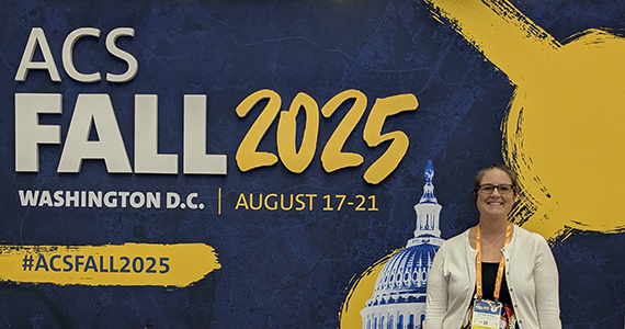 Natalie Shaak standing in from of ACS Fall 2025 sign 