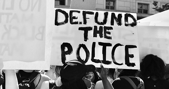 Protestors Holding Signs that say "defund the police"