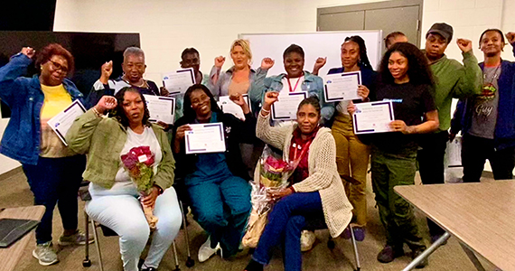Group of diverse members holding certificates and raising fists