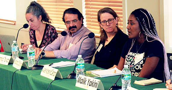 Four panelist sitting at table, one speaking