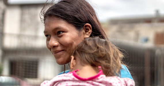 woman in Latin America carrying child 