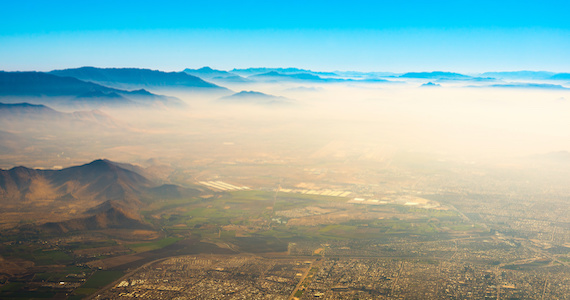 Aerial view of Santiago de Chile under a layer of smog trapped between the hills