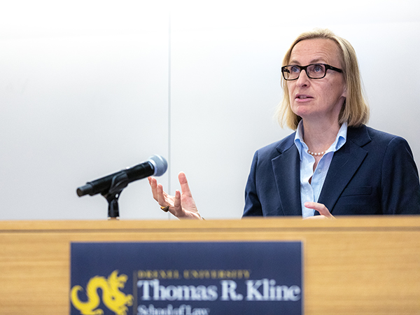 A clinic student speaks at a podium.