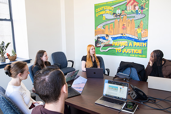 Students discuss their work in a conference room at the Philadelphia Legal Assistance office.