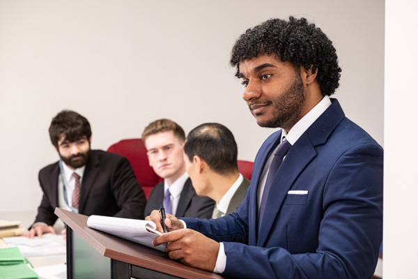 A student stands at the lectern in the Defender Association practice courtroom.