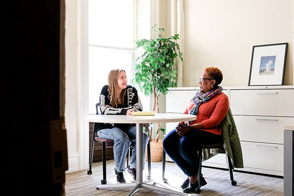 Two people talking while sitting at a table in the Dornsife Center for Neighborhood Partnerships