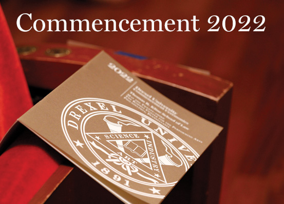 Photo of Kline Law's 2022 Commencement program, which has a gold cover with white text. The program is on a red chair at Kimmel Cultural Campus, where the ceremony took place.